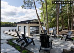 there are many lawn chairs on the side of the water and in front of a boat dock