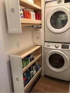 a washer and dryer in a small room with open shelves on the wall