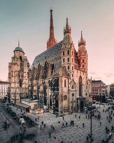 an aerial view of a cathedral with many spires and people walking around the courtyard