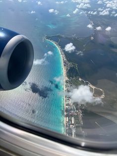 an airplane wing flying over the ocean and land