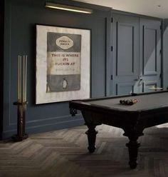 a pool table in the middle of a room with blue walls and wood flooring