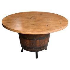 a round wooden table sitting on top of an old barrel with holes in the middle