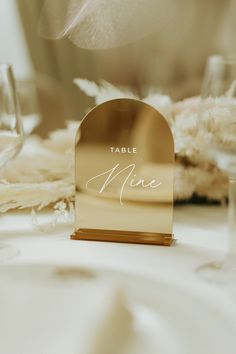 a table setting with place cards and wine glasses