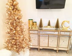 a gold christmas tree in front of a flat screen tv