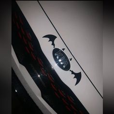 the front end of a white car with bats on it