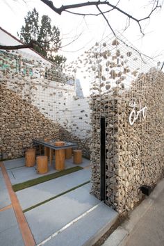 a building made out of stacked rocks with writing on the front and side walls that read,