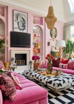 a living room filled with pink couches and pillows