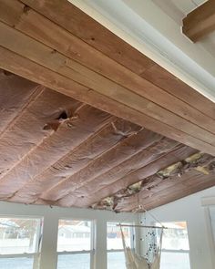 an unfinished ceiling with wooden beams and hanging hammock