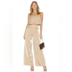 Lovers + Friends Zoey Wide Leg Pants Metallic Gold Cocktail Party Glam Xs New. New Lovers + Friends Zoey Wide Leg Pants In Light Gold. Metallic Finish. High Waist With Hidden Side Zipper Closure. Marked Size Xs. A Flowing Length Of Luminous Fabric And A Dash Of Fluttery Movement Transforms These Wide-Leg Pants Into Night-Out Gold. Side Zip Closure Lined 67% Rayon, 33% Nylon Hand Wash, Dry Flat Waist - Approx. 11" Flat Hips - Approx. 16" Flat Length - 43" Inseam - 32" Rise - 12" Nwt. Tag May Have Glamorous Summer Evening Wide Leg Pants, Glamorous Evening Wide Leg Pants For Summer, Glamorous Wide Leg Pants For Summer Evenings, Glamorous Summer Wide Leg Pants, Spring Party Trousers Set, Spring Party Trouser Sets, Spring Party Sets With Trousers, Wide Leg Pants For Summer Date Night, Glamorous Summer Sleeveless Set