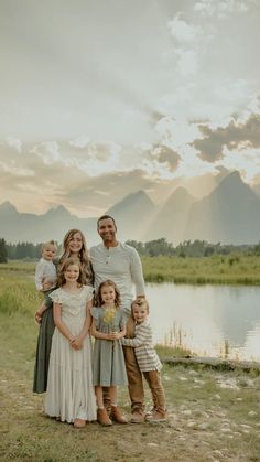 a family standing in front of a lake at sunset