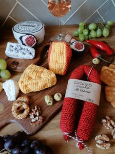 a wooden cutting board topped with different types of food and wine glasses filled with wine