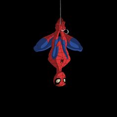 a spider man hanging upside down in the dark