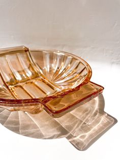 an empty glass dish sitting on top of a table