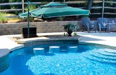 an outdoor swimming pool with chairs and umbrellas