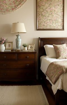 a bedroom with a bed, dresser and two framed pictures on the wall above it