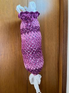 a purple and white bag hanging from a wooden door