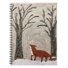 a spiral notebook with an image of a red fox in the snow and trees on it