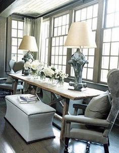 a living room filled with lots of furniture and flowers on top of a wooden table