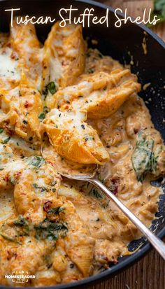 a skillet filled with chicken, cheese and spinach