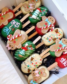 an open box filled with decorated cookies and wooden spoons on top of each other