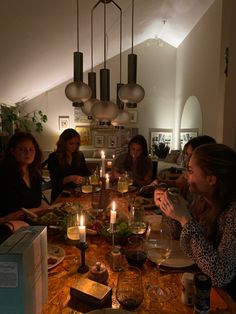 a group of people sitting around a table with food and drinks