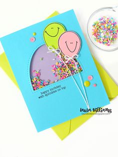 a happy birthday card with balloons and sprinkles on the bottom, next to a bowl of confetti