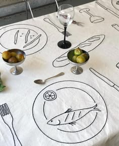 a table topped with plates and bowls filled with food next to utensils on top of a white table cloth