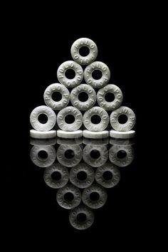 a stack of white doughnuts sitting on top of a black table next to a mirror