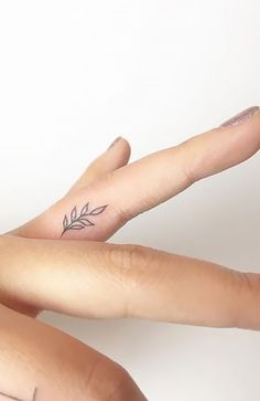 two fingers that have tattoos on them and one has a leaf tattoo on the middle finger