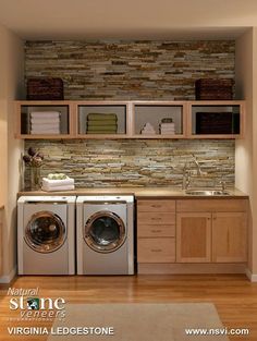 a washer and dryer in a small room with wood flooring on the walls