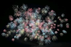 fireworks are lit up in the night sky with many colors and shapes on display,