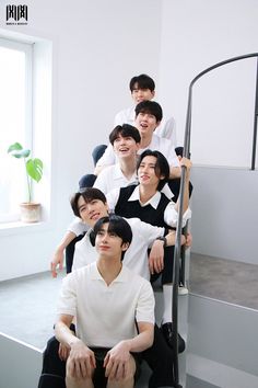 a group of young men sitting next to each other on top of a set of stairs