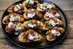 small appetizers with meat and cheese are on a black plate, ready to be eaten