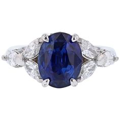 This ring is made in Platinum and features one GRS certified Oval Cut, Natural Blue Sapphire weighing 5.01ct, prong set, originating from Sri Lanka. The GRS report number is GRS2014-077118. The ring also has a features 6 Marquise cut diamonds weighing 1.04cts and 40 round cut diamonds weighing 0.25cts with a color grade (H) clarity grade (SI2). Modern Diamond Jewelry, Royal Rings, Oval Cut Diamond Rings, Diamond Three Stone Ring, Contemporary Engagement Rings, Platinum Diamond Engagement Rings, Modern Engagement Rings, Ceylon Sapphire, Three Stone Diamond