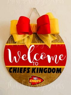 a sign that says welcome to chiefs kingdom hanging on the wall in front of a white wall