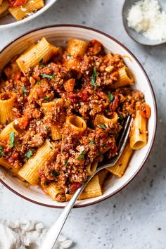 two bowls filled with pasta and meat sauce