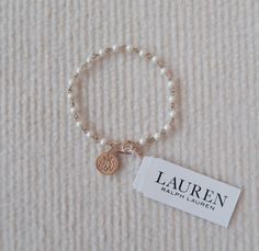 Elegant and timeless, this Ralph Lauren bracelet features mini faux pearls and a chic deco-style design. The piece is accented with the iconic Ralph Lauren logo charm, offering a touch of sophistication to any outfit and perfect for adding a subtle statement to your look Signature Ralph Lauren logo charm. Length: 19cm. Pearl: 0.4cm in Width. Ralph Lauren Bracelet, Ralph Lauren Logo, Style Deco, Deco Style, Faux Pearl, Singapore, Beauty Book, Jewelry Bracelets, Accessory Gift