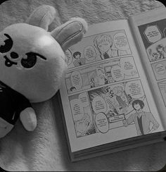 a stuffed animal is next to an open comic book