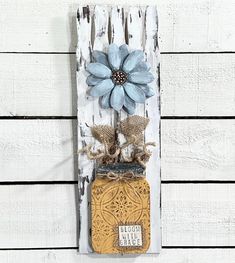 a wooden sign with a mason jar and blue flower on it's side hanging from the wall