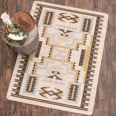 a brown and white rug sitting on top of a wooden floor next to a potted plant