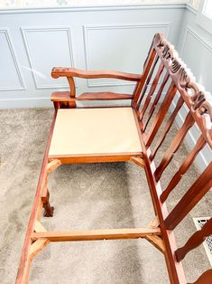 a wooden rocking chair sitting on top of a carpeted floor