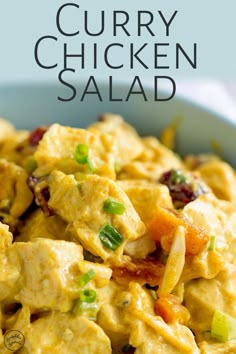 a bowl filled with curry chicken salad on top of a table