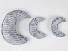 three crocheted objects sitting on top of a white surface