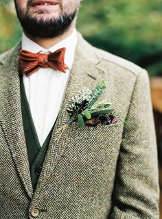 a man in a suit with a bow tie and boutonniere on his lapel