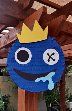 a paper cut out of a blue monster with a crown