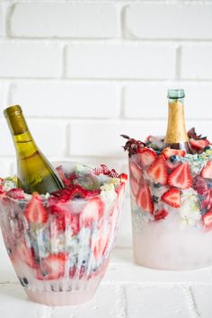 two pictures of wine bottles in ice with strawberries and flowers on them, one is filled with champagne