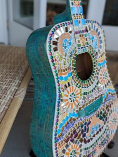 a colorful guitar sitting on top of a wooden table