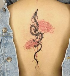 a woman's back with a snake and flowers tattoo on her left side ribcage