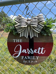 the jarrett family sign hanging on a chain link fence in front of a grassy field