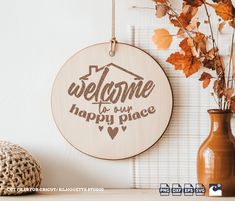 a wooden sign that says welcome to our happy place next to a vase with flowers